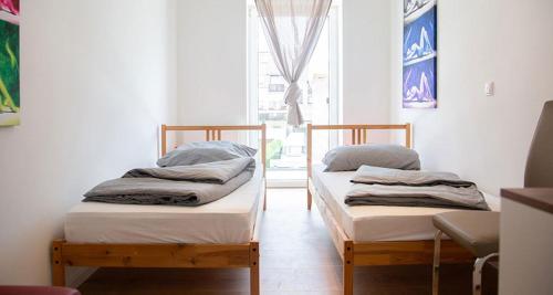two twin beds in a room with a window at Meisterhaus Apartments in Glauchau