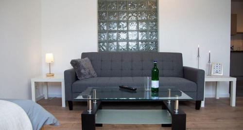 a living room with a couch and a glass table at Meisterhaus Apartments in Glauchau