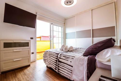 - une chambre avec un lit et 2 serviettes dans l'établissement Rentaliday Estrella Marazul, à Las Galletas
