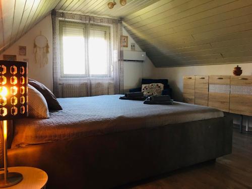 sypialnia z dużym łóżkiem i oknem w obiekcie Csendes Vendégház, Families, Hikers & Bikers w mieście Cserszegtomaj