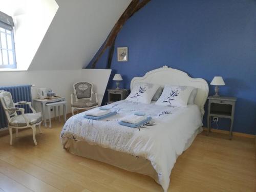 1 dormitorio con 1 cama blanca y paredes azules en Clos de la ruche, en Cour-sur-Loire
