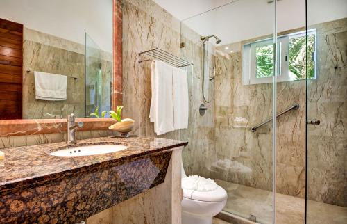 a bathroom with a shower and a sink and a toilet at Estudio Casa Jaguar in Puerto Aventuras