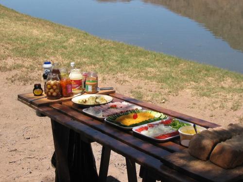 une table de pique-nique avec de la nourriture dessus dans l'établissement Bundi Orange River Camp, à Noordoewer
