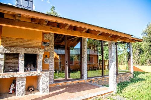 uma casa com lareira de pedra no quintal em Lagunas de Sanabria em Trefacio