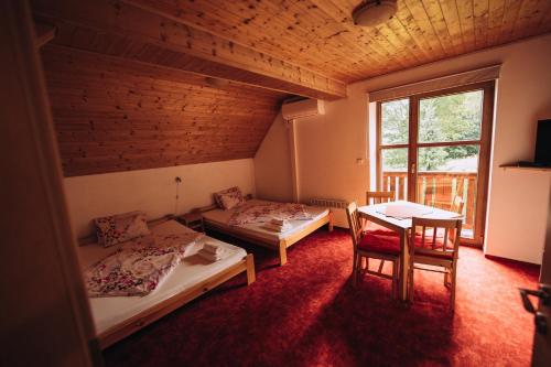 a room with two beds and a table and a window at Chata Boubín in Kubova Huť