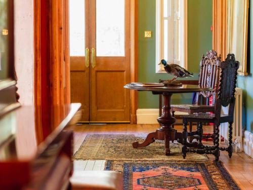 a bird sitting on top of a table in a room at Dalnaglar Castle in Blairgowrie