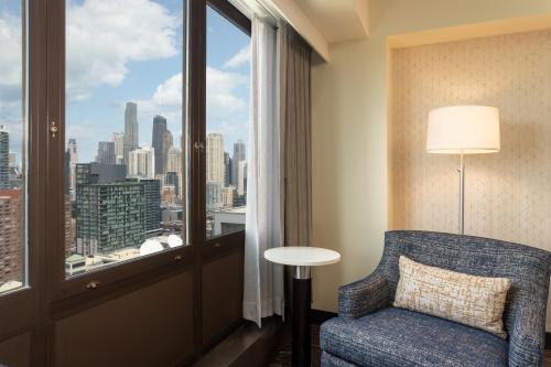 a room with a chair and a window with a view at Holiday Inn - Chicago Dwtn - Wolf Point, an IHG Hotel in Chicago