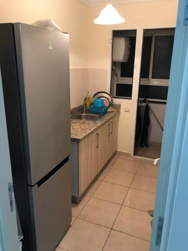 a kitchen with a refrigerator and a sink at Appartamento per famiglia con mare e acquapark di frontecasa in Sidi Rahal