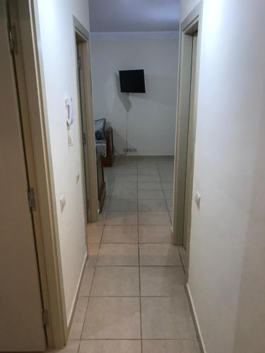 a hallway with a tiled floor and a television at Appartamento per famiglia con mare e acquapark di frontecasa in Sidi Rahal