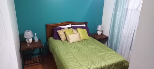 um quarto com uma cama verde e duas mesas em Dota es Dota em Santa María