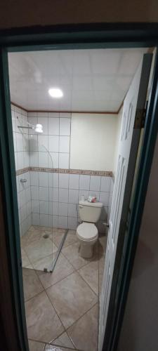 a bathroom with a toilet and a glass door at Dota es Dota in Santa María