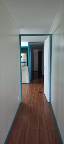 um quarto vazio com um corredor com piso de madeira em Dota es Dota em Santa María