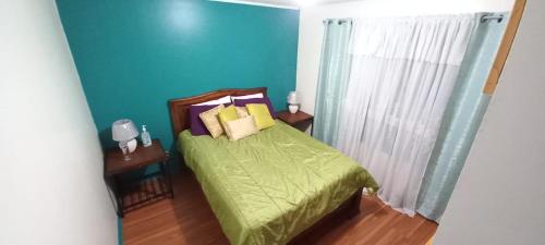 um quarto com uma cama verde e uma parede azul em Dota es Dota em Santa María