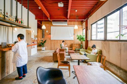 a man standing in a room with tables and chairs at fan! ABURATSU in Nichinan