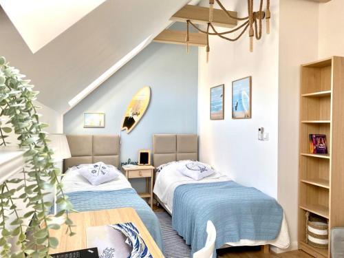 2 łóżka w pokoju z niebieskimi ścianami w obiekcie White Wave Norda Dębki w Dębkach