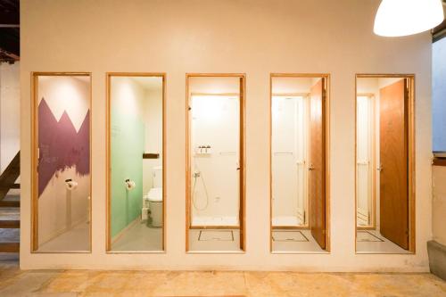 a group of glass doors on a wall with a bathroom at fan! -ABURATSU- Sports Bar ＆ HOSTEL in Nichinan