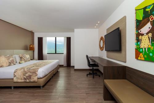 a hotel room with a bed and a desk at Hotel Mocawa Plaza Armenia in Armenia