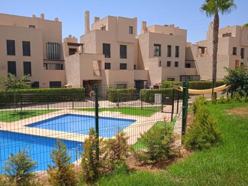 una pista de tenis frente a algunos edificios en Hermoso piso para 4 Pax Corvera Golf Country Club en Corvera