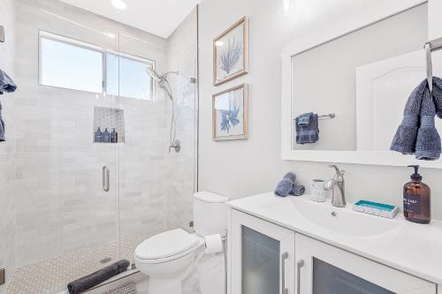 a white bathroom with a toilet and a shower at Sunset Villa in San Diego