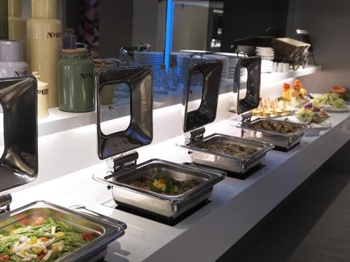 a buffet with several trays of food on a counter at CityInn Hotel Plus - Taichung Station Branch in Taichung