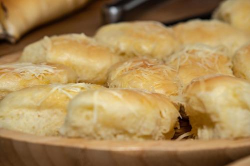 a wooden plate of dumplings with cheese on it at HOTEL PORTO in Valença
