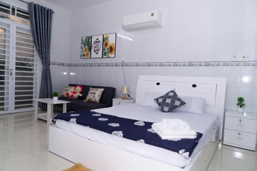 a white bedroom with a bed and a couch at Nina homestay P1,P4 in Ap My Quo