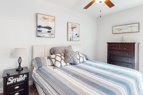 a bedroom with a bed and a dresser in it at Cast a Waves in Panama City Beach