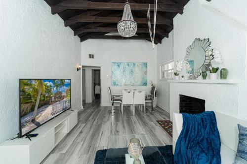 a living room with a tv and a dining room at Bike to Beach-Spacious With Patio BBQ & Game Room (Pet-Friendly) in Hallandale Beach