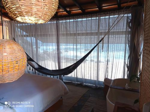 a bedroom with a hammock in front of a window at Hotel Bendita Luna Salchi in Cuatunalco