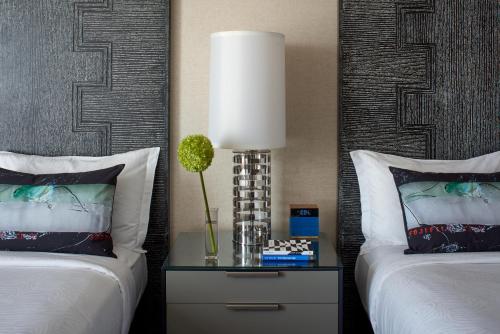 a bedroom with two beds and a table with a lamp at Kimpton Hotel Palomar Los Angeles Beverly Hills by IHG in Los Angeles