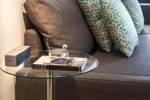a glass table with books on it next to a couch at BO - Almada in Porto