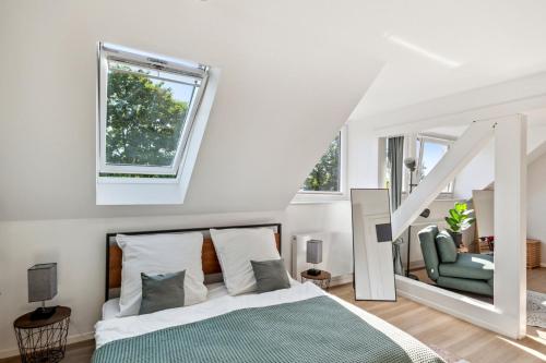 a white bedroom with a bed and a staircase at Your home away from home - A workplace in every room in Hannover