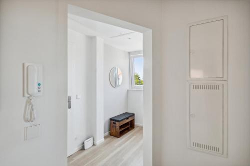 a white hallway with a door and a window at Your home away from home - A workplace in every room in Hannover