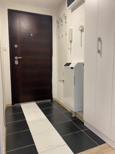 ein Bad mit einer Tür und einem schwarz-weißen Fliesenboden in der Unterkunft DREAM APARTMENTS in Surčin