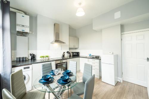 a kitchen with a glass table with blue dishes on it at Sheffield Contractors and MONTHLY Stays 3BR 3 Bath house Managed by Chique Properties Ltd in Brightside