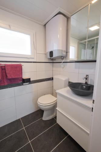 a white bathroom with a toilet and a sink at Lake Getaway Apartment with Private entrance, right on the Lake Constance cycle path, barbecue area, free wifi, Netflix and free bikes in Salmsach