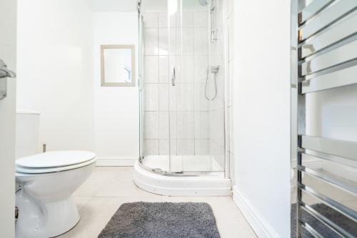 een badkamer met een douche, een toilet en een tapijt bij Sheffield Contractors Stays- Sleeps 6, 3 bed 3 bath house. Managed by Chique Properties Ltd in Brightside