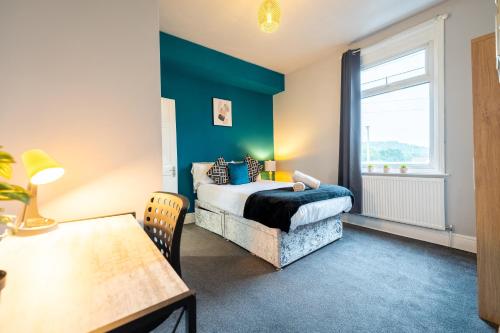 um quarto com uma cama, uma mesa e uma janela em Sheffield Contractors Stays- Sleeps 6, 3 bed 3 bath house. Managed by Chique Properties Ltd em Brightside