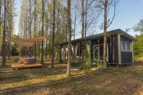 una casita en el bosque con una hamaca en Drina River Glamping en Loznica