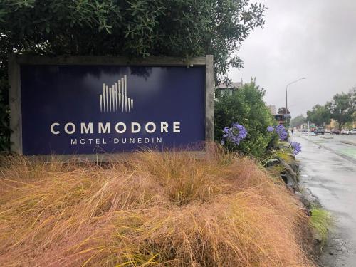 a sign for a motel compound on the side of a road at Commodore Motel in Dunedin