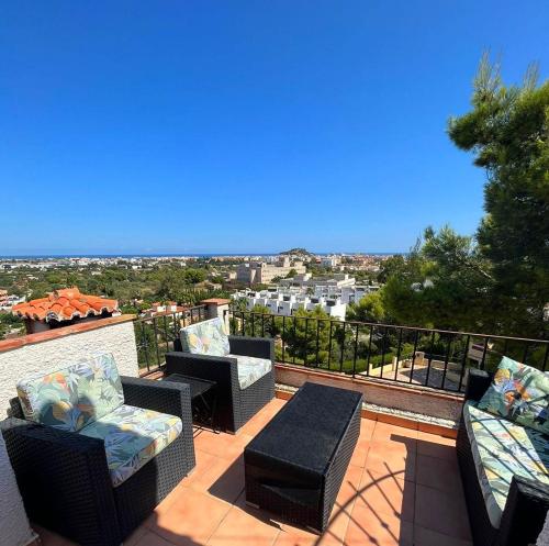 a patio with chairs and tables on a balcony at Villa vistas panorámicas in Denia