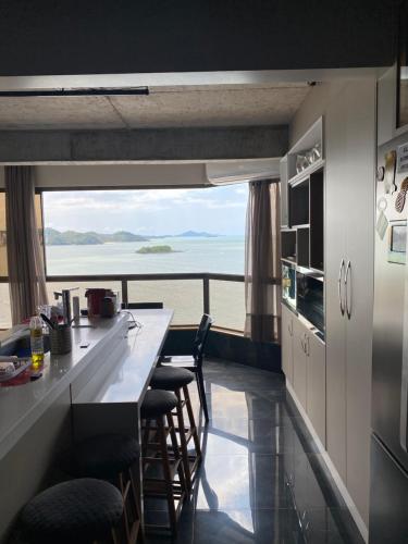 a kitchen with a counter and a view of the ocean at Apartamento 4 quartos Beira Mar Balneário Camboriú in Balneário Camboriú
