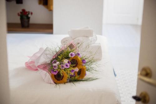 a bouquet of flowers sitting on a bed at Novecento in Campobasso