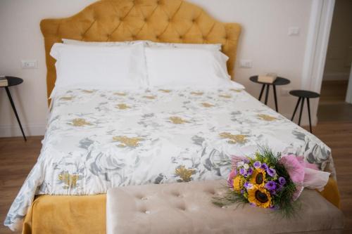 een bed met een wit dekbed met een bloemstuk erop bij Novecento in Campobasso
