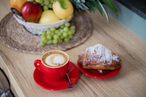 a table with a cup of coffee and a plate of fruit at Novecento in Campobasso