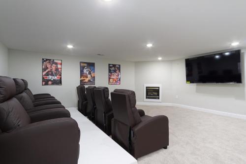 a waiting room with leather chairs and a flat screen tv at Secluded oasis in Asheville! GAME room MOVIE theater HOT tub - 20 min to Biltmore! in Fairview