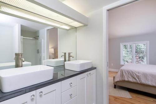 a bathroom with two sinks and a large mirror at Secluded oasis in Asheville! GAME room MOVIE theater HOT tub - 20 min to Biltmore! in Fairview