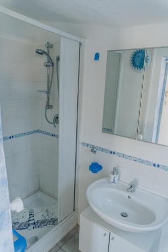 a white bathroom with a sink and a shower at Casa vacanze Montereale in Realmonte