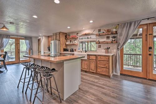 a kitchen with wooden cabinets and a island with bar stools at Hot Tub, Game Room Dog-Friendly Pine Cabin! in Pine
