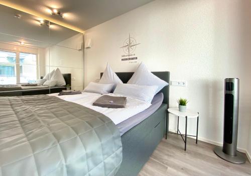 ein Schlafzimmer mit einem großen Bett und einem Laptop darauf in der Unterkunft Auszeit Apartment STYLE am Uferpark - nur 100 m bis zum Bodensee, direkt am Bodenseeradweg, Sonnenbalkon, schnelles WLAN, kostenloser Tiefgaragenstellplatz, für bis zu 2 Personen in Friedrichshafen